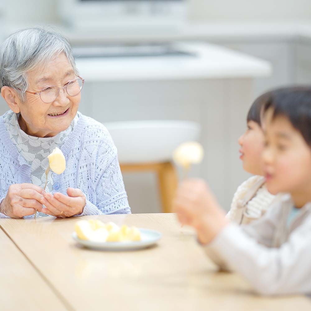 りんごを一緒に食べるおばあちゃんと子どもたち